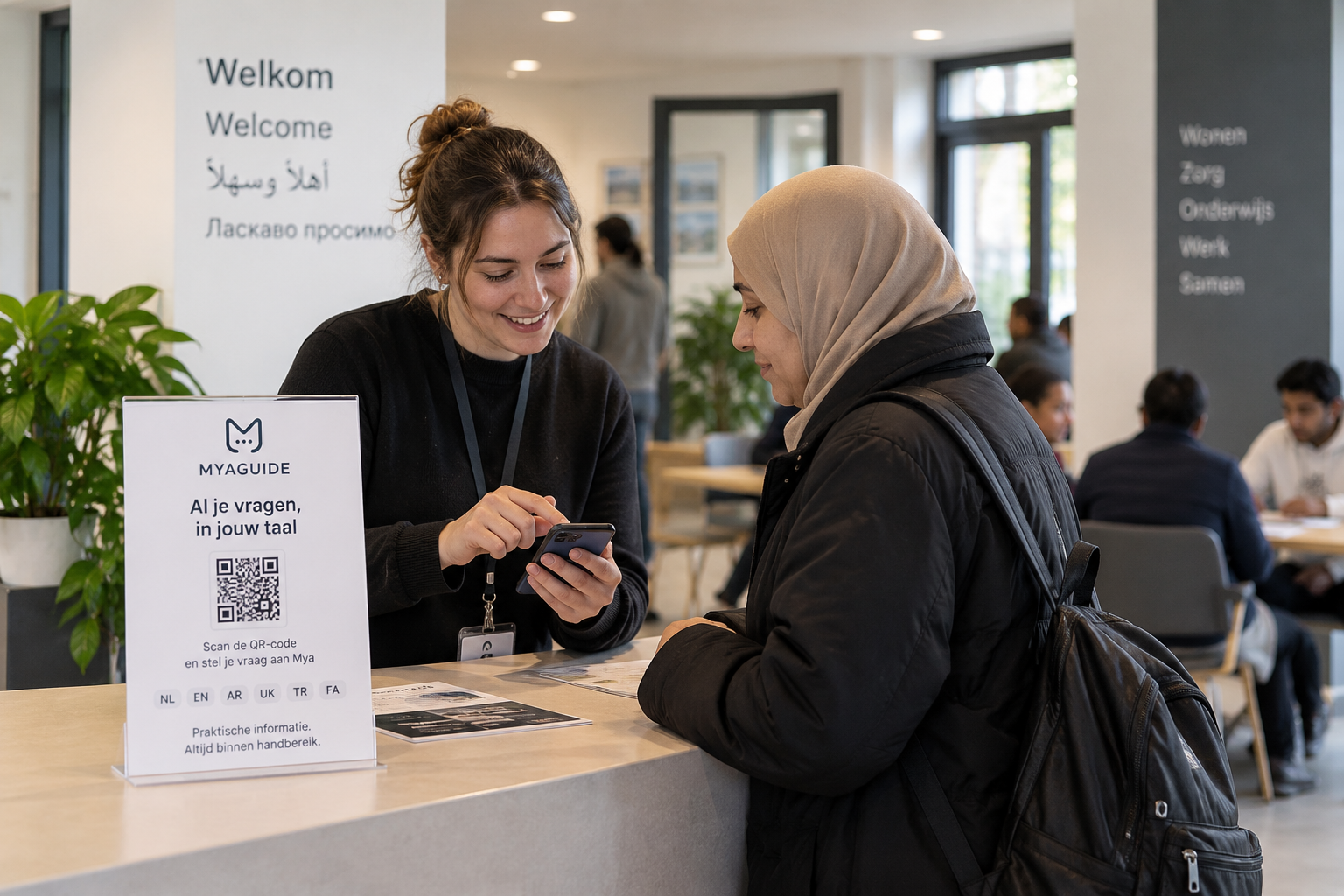 Een medewerker helpt een bewoner met MyaGuide bij de receptie van een opvanglocatie.